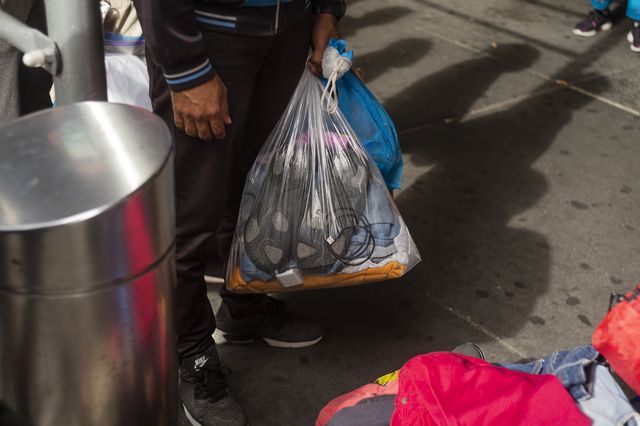 A group of people from Central and South America seeking asylum wait in line to be helped by mutual aid volunteers outside of Port Authority early on Wednesday, August 10. The group of 80-100 traveled from Texas by bus.